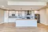 Modern kitchen with sleek white cabinetry, stainless steel appliances, and stylish pendant lighting over a spacious island.