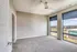 Bright and spacious unfurnished room with large windows offering a panoramic city view and abundant natural light.