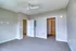 Bright and spacious bedroom with soft carpet flooring, modern ceiling fan, and ample natural light, leading to a walk-in closet.