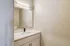Sleek and modern bathroom with elegant vanity, large mirror, and stylish lighting.