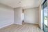 Bright, spacious room with elegant wooden flooring and large window offering scenic views.