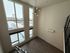 Bright and spacious apartment with large windows offering a stunning urban view, modern lighting, and sleek hardwood floors.
