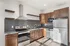 Modern kitchen with sleek stainless steel appliances, elegant wooden cabinets, and open shelving, perfect for stylish culinary adventures.