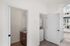 Chic apartment featuring a compact laundry room with a stacked washer-dryer and a cozy bathroom with wooden cabinetry, complemented by natural light.