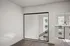 Modern interior showcasing a spacious room with large mirrored closet doors, sleek metal railing, and abundant natural light.