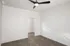 Bright, spacious room with sleek wood flooring and modern ceiling fan, featuring a built-in closet space.