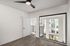 Bright and modern room with large floor-to-ceiling windows, sleek ceiling fan, and elegant wooden flooring, offering a fresh and inviting space.
