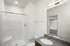Modern bathroom with a sleek glass shower, elegant vanity, and ample natural light.