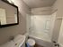 Modern bathroom featuring a sleek bathtub and elegant vanity with a large mirror.