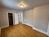 Inviting bedroom with warm wooden flooring, spacious closet, and modern lighting.