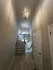 Elegant hallway with modern chandelier leading to a well-lit staircase in a contemporary apartment.