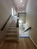 Modern staircase leading to a bright and spacious upper level with hardwood flooring and stylish lighting.
