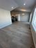 Spacious open-concept kitchen and dining area with modern lighting and expansive wood flooring, perfect for entertaining.