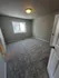 Bright and airy bedroom with plush carpet and modern lighting, perfect for a restful retreat.