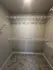 Spacious walk-in closet with ample shelving and neutral carpeting, perfect for organized storage.