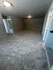 Spacious living room featuring plush carpet flooring and ambient lighting, ideal for cozy gatherings.