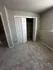 Cozy, freshly carpeted bedroom featuring a spacious closet with white double doors, enhancing modern living.