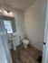 Modern bathroom with elegant wood flooring, sleek pedestal sink, and stylish lighting fixture.