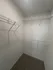Spacious walk-in closet with ample shelving and a neutral color palette.