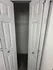 Elegant white double doors opening to a spacious and organized closet with plush carpet flooring.