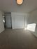 Bright and spacious room with plush carpet, neutral walls, and ample closet space under soft ceiling lighting.