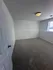 Bright and inviting bedroom space with plush carpet and natural light from a large window.