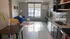 Modern studio apartment featuring an open kitchen with sleek countertops, cozy living area with a blue velvet sofa, and large window for natural light.