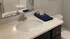 Elegant bathroom with a sleek white countertop, modern faucet, and neatly folded towels.