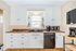 Modern kitchen with sleek white cabinets, granite countertops, and stylish appliances.