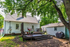 Charming backyard with cozy wooden deck, shaded by lush trees, perfect for outdoor relaxation and entertaining.