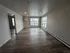 Bright and spacious living area with modern wood flooring, large windows, and sleek design in a contemporary apartment.