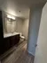 Elegant bathroom featuring a sleek vanity with marble countertop, modern lighting, and rich wood cabinetry, complemented by sophisticated flooring.