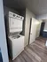 Convenient in-unit laundry with modern stacked washer and dryer, elegantly set against sleek wood flooring.