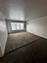 Bright living room with large window, cozy carpeted area, and sleek wood flooring.