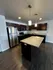 Modern kitchen with sleek dark cabinets, stainless steel appliances, and a spacious granite island, perfect for entertaining.