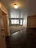 Inviting apartment entrance showcasing a blend of elegant hardwood and cozy carpet with abundant natural light.