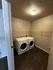 Modern laundry room with front-loading washer and dryer, enhanced by spacious shelving and sleek flooring.