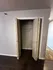 Contemporary closet space with open double doors, featuring sleek design and hardwood floors.