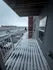 Charming balcony with snow-covered decking offering a view of nearby modern apartments and garages, perfect for a cozy winter atmosphere.