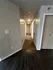 Inviting apartment hallway with modern wood and carpet flooring, softly lit by ceiling lights for a cozy ambiance.