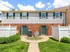 image of two townhome entrances each flanked by private patio. Townhomes have brick exteriors on first floor with siding on the second floor.