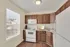 Kitchen with oak cabinets, white appliances, and vinyl plank flooring.