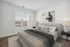 Bedroom with large window showing space for queen bed with. night stables.