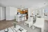 View from living area showing open-concept layout, separate dining area surrounded by windows, and kitchen with island & pendant lighting.