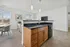 Image of kitchen island with granite countertop and pendant lighting with dishwasher & cabinets for storage.