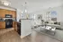 View from kitchen into living & dining areas with a wall full of windows in an open-concept floorplan.