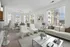 Spacious living room showing large couch & coffee table with windows overlooking mountain views.