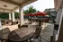 Outdoor dining area showing five tables, two under shade