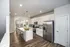 Contemporary kitchen with white cabinetry, stainless steel appliances, and a large central island with seating.