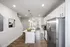Contemporary kitchen with stainless steel appliances, white cabinets, and a cozy dining area.